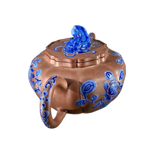 144 - A CHINESE YIXING CLAY TEAPOT WITH BLUE ENAMELLED DECORATIONShowing blue floral decoration and Dog of... 