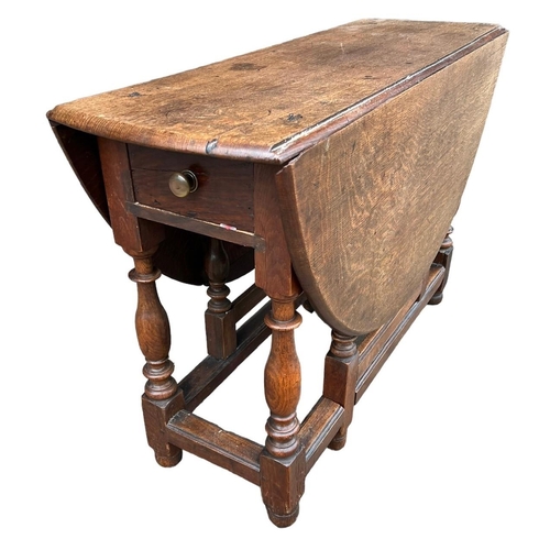 246 - AN 18TH CENTURY OAK GATELEG TABLE The single drawer, raised on turned legs joined by stretcher. (h 7... 