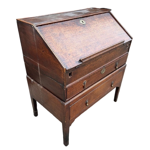 248 - AN 18TH CENTURY TWO SECTION OAK WRITING BUREAU The fall front opening to reveal fitted interior abov... 