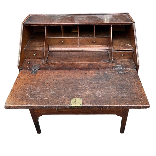 248 - AN 18TH CENTURY TWO SECTION OAK WRITING BUREAU The fall front opening to reveal fitted interior abov... 