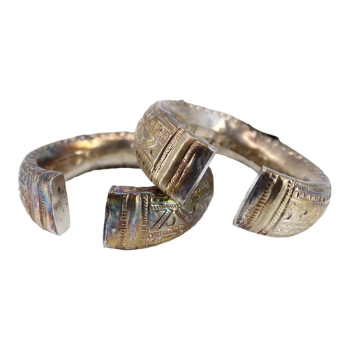 62 - A PAIR OF LATE 19TH EARLY 20TH CENTURY OMANI SILVER ELBOW-RINGS, TOGETHER WITH OMANI SILVER FERTILIT... 