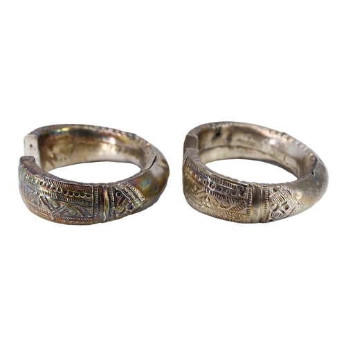 62 - A PAIR OF LATE 19TH EARLY 20TH CENTURY OMANI SILVER ELBOW-RINGS, TOGETHER WITH OMANI SILVER FERTILIT... 