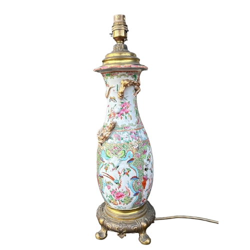 129 - A 19TH CENTURY CHINESE CANTON FAMILLE ROSE PORCELAIN LAMP ON STYLISED GILT ORMOLU BASEGround decorat... 