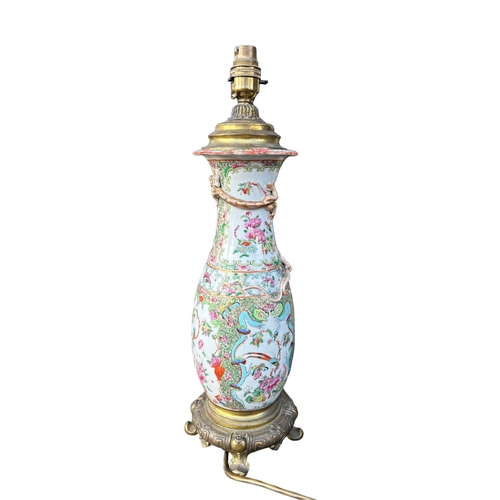 129 - A 19TH CENTURY CHINESE CANTON FAMILLE ROSE PORCELAIN LAMP ON STYLISED GILT ORMOLU BASEGround decorat... 