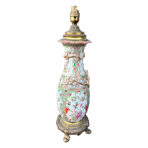 129 - A 19TH CENTURY CHINESE CANTON FAMILLE ROSE PORCELAIN LAMP ON STYLISED GILT ORMOLU BASEGround decorat... 