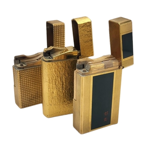 41 - ST. DUPONT, PARIS, TWO LIGNE 1 AND LIGNE 2 GOLD PLATED LIGHTERS 
Together with gold plated Dunhill l... 