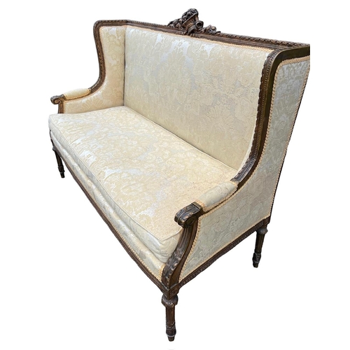 216 - A 19TH CENTURY FRENCH LOUIS XVI DESIGN CARVED GILTWOOD WINGBACK SETTEE
The back carved with a centra... 