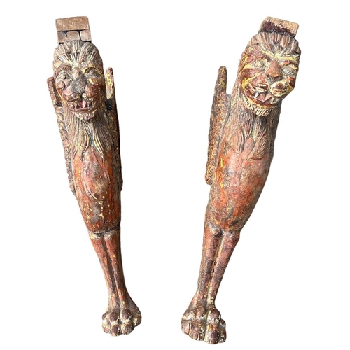 228 - A PAIR OF ANTIQUE CARVED HARDWOOD AND POLYCHROME TABLE SUPPORTS IN THE FORM A MYTHICAL WINGED LION. ... 