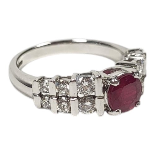 97A - AN 18CT WHITE GOLD, RUBY AND DIAMOND RINGSet with a single round cut ruby with two rows of graduate... 