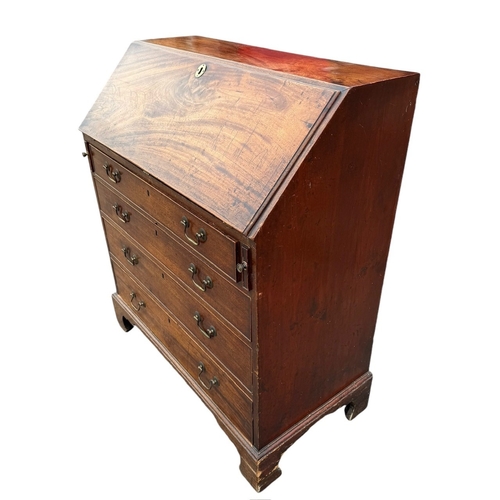 14 - A GEORGE III MAHOGANY BUREAU 
The hinged top opening to reveal fitted interior above four long gradu... 