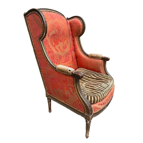 36 - AN EARLY 19TH CENTURY FRENCH CARVED GILTWOOD AND UPHOLSTERED WINGBACK ARMCHAIR
The shaped back above... 