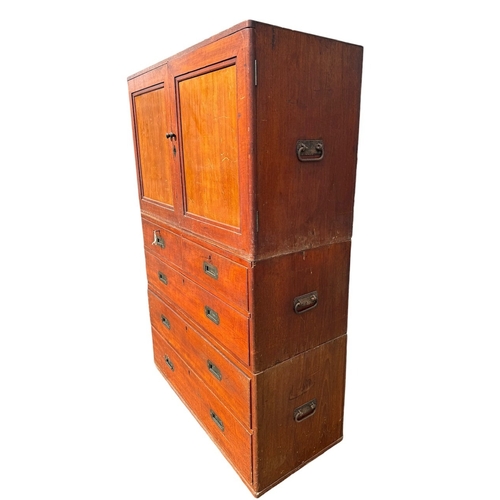 38 - AN EARLY 19TH CENTURY TEAK CAMPAIGN THREE SECTION CHEST 
The top with two panel doors opening to rev... 