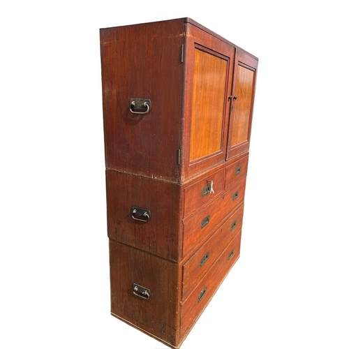 38 - AN EARLY 19TH CENTURY TEAK CAMPAIGN THREE SECTION CHEST 
The top with two panel doors opening to rev... 