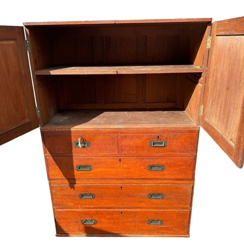 38 - AN EARLY 19TH CENTURY TEAK CAMPAIGN THREE SECTION CHEST 
The top with two panel doors opening to rev... 