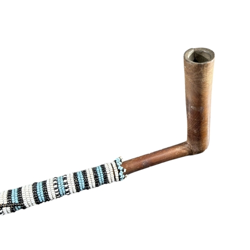 120 - A SOUTH AFRICAN ZULU SMOKING PIPE
Decorated with coloured glass beads. 
(length 30.2cm)