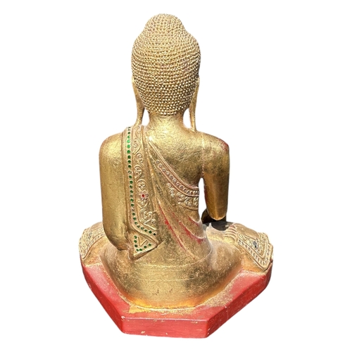 140 - A BURMESE CARVED WOOD AND GILT FIGURE OF A SEATED BUDDHA
Encrusted with various coloured glass decor... 