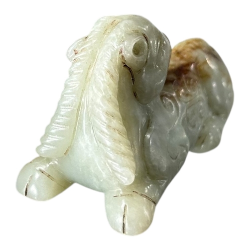 172 - QING DYNASTY CARVED PALE CELADON JADE OF A RAM
Modelled with head turned fully backwards, legs tucke... 