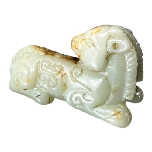 172 - QING DYNASTY CARVED PALE CELADON JADE OF A RAM
Modelled with head turned fully backwards, legs tucke... 