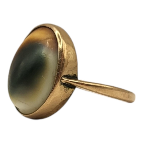 196 - A VICTORIAN 9CT GOLD AND OPERCULUM SHELL RING
Having bezel set cabochon shell front (approx. 15mm x ... 