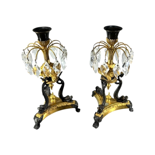 123 - A PAIR OF 19TH CENTURY FRENCH REGENCY GILT BRONZE AND PATINATED CANDLESTICKS
Decorated with a spray ... 