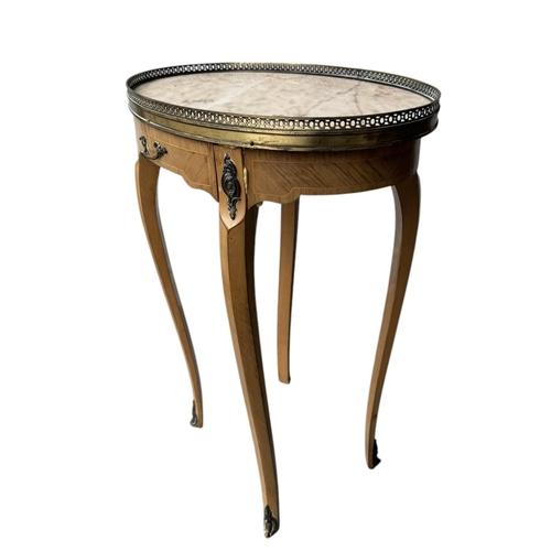 25 - A 19TH CENTURY STYLE FRENCH SIDE TABLE,
The oval marble top with pierced brass gallery above a singl... 