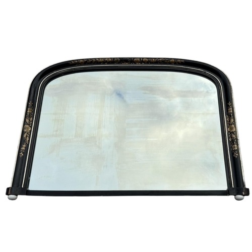 29 - A VICTORIAN OVERMANTLE MIRROR
With gilt decorated ebonised frame and arched plate, on white china bu... 