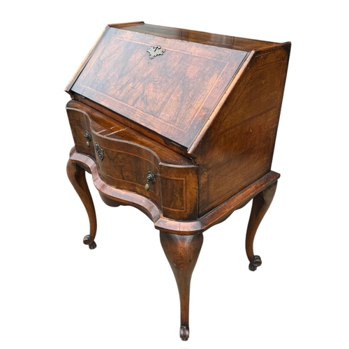 35 - AN EARLY 20TH CENTURY QUEEN ANNE STYLE  WALNUT AND INLAID FREESTANDING LADIES’ WRITING BUREAU
The fa... 