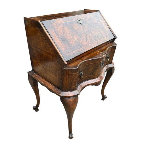 35 - AN EARLY 20TH CENTURY QUEEN ANNE STYLE  WALNUT AND INLAID FREESTANDING LADIES’ WRITING BUREAU
The fa... 