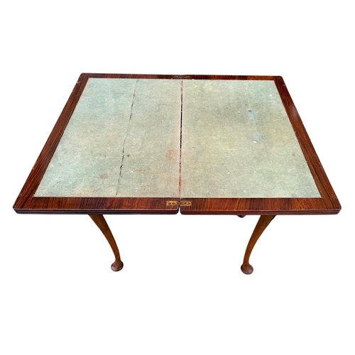 43 - A GEORGIAN STYLE WALNUT FOLD OVER CARD TABLE
The rectangular top enclosing a green baize playing sur... 