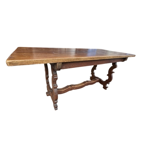 44 - A SPANISH STAINED BEECHWOOD REFECTORY TABLE
The rectangular top raised on lyre ends joined by a stre... 