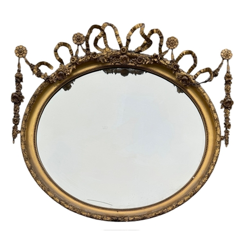 5A - A 19TH CENTURY ADAMS REVIVAL GILTWOOD AND GESSO OVAL MIRROR
Decorated with ribbons flowerheads and f... 