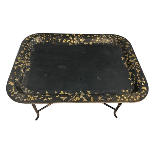 9A - A 19TH CENTURY BLACK LACQUER PAPIER-MACHE TRAY TABLE
With gilt decoration.
(h 50.5cm x d 58cm x w 78... 