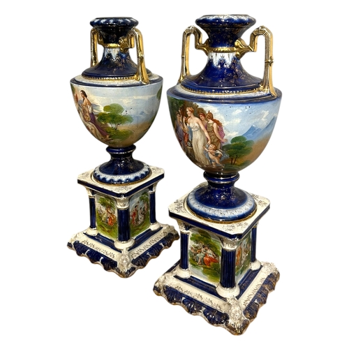 147A - A.G. HARLEY JONES, AN EDWARDIAN PAIR OF HAND PAINTED STONEWARE TWIN HANDLED VASES/URNS
On columned s... 