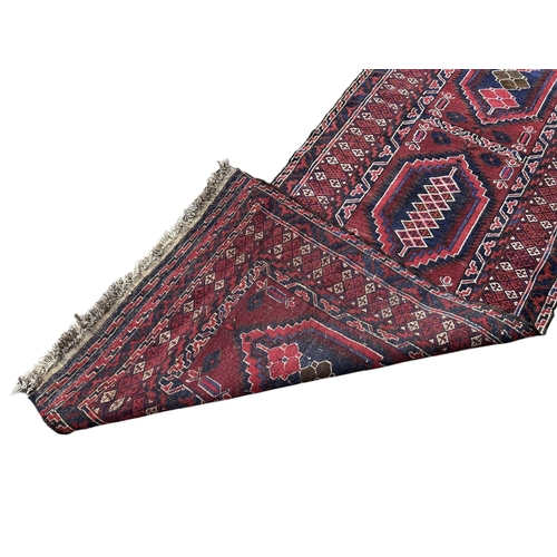 14A - A 20TH CENTURY RED GROUND RUNNER (PROBABLY AFGHAN).
(255cm x 74.5cm)