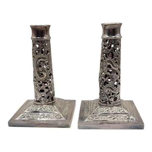 149 - WANG HING, HONG KONG, A PAIR OF LATE 19TH CENTURY CHINESE SILVER CANDLESTICKS
Having a pierced openw... 