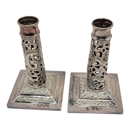 149 - WANG HING, HONG KONG, A PAIR OF LATE 19TH CENTURY CHINESE SILVER CANDLESTICKS
Having a pierced openw... 