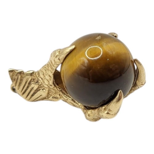 40 - A LARGE 9CT GOLD AND TIGER'S EYE EAGLES CLAW AND BALL CHARM, HALLMARKED LONDON, 1966. 
(h 25mm x w 1... 