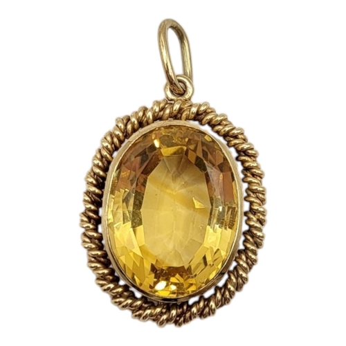 48 - A LARGE 20TH CENTURY YELLOW METAL AND CITRINE PENDANT (YELLOW METAL TESTED AS 9CT GOLD)
Oval form ha... 