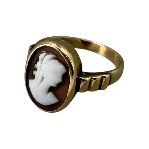 521 - A LATE VICTORIAN 12CT GOLD AND CARVED SHELL CAMEO RING
Oval form, carved shell cameo depicting a bus... 