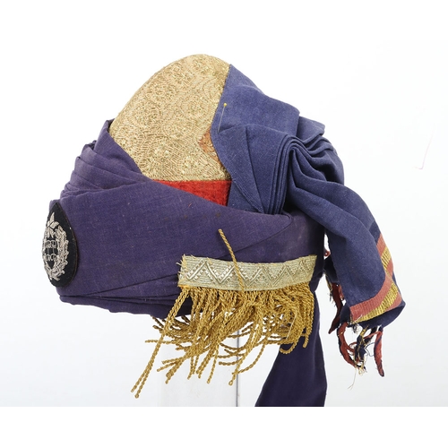52 - Indian Turban, of recent manufacture, made from blue cloth with gilt embroidery and badge ( glued to... 