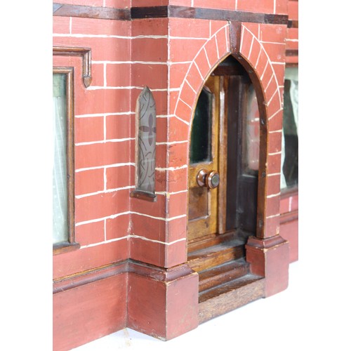2 - A good painted red brick wooden Victorian Dolls house in the Gothic style, with contents, the façade... 