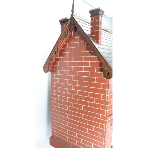 2 - A good painted red brick wooden Victorian Dolls house in the Gothic style, with contents, the façade... 