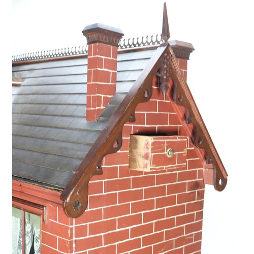 2 - A good painted red brick wooden Victorian Dolls house in the Gothic style, with contents, the façade... 