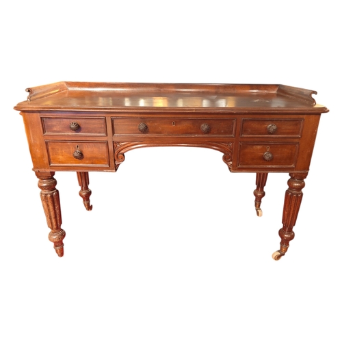 117 - A Victorian mahogany writing desk with 5 drawers & frieze top on reeded turned legs 120cm wide.