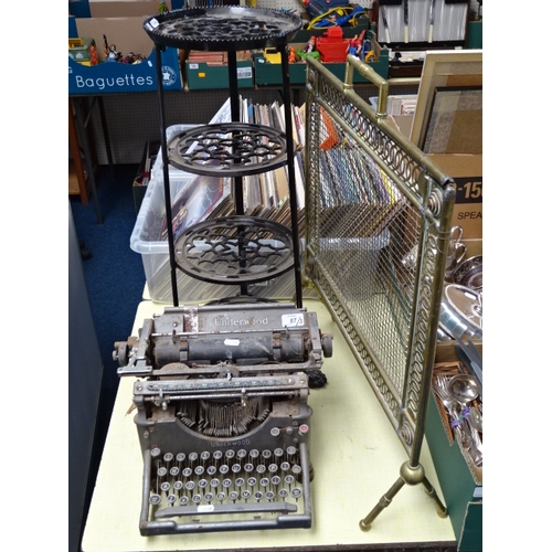 87 - An iron pan stand, an Underwood typewriter, a brass firescreen, early 20th cent. (3)