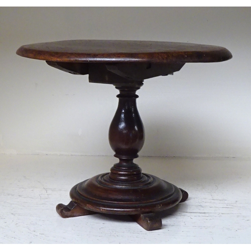 145 - A miniature circular tilt top table