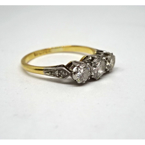 368 - A trilogy ring comprising three brilliant cut white stones in a white metal raised claw setting on a... 