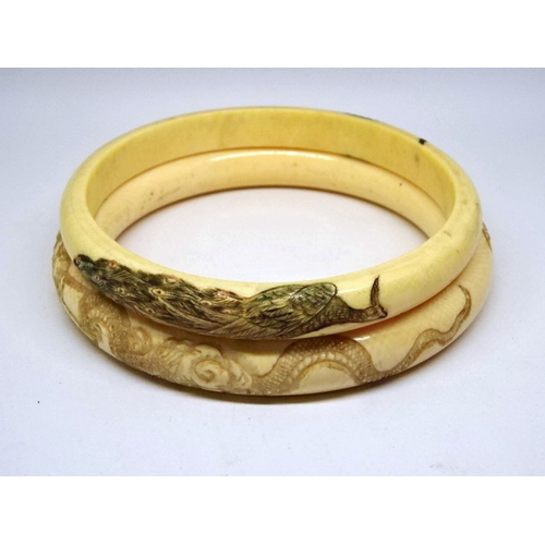 450 - Two Japanese bangles having carved decoration.  Approximately 75mm internal diameters.