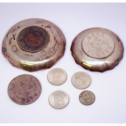 441 - Two white metal nut dishes inset with Chinese coins; a single Chinese coin. (3)