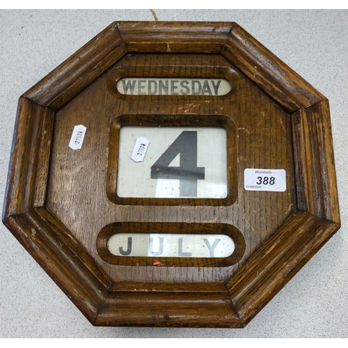 388 - A wall mounted oak calendar.